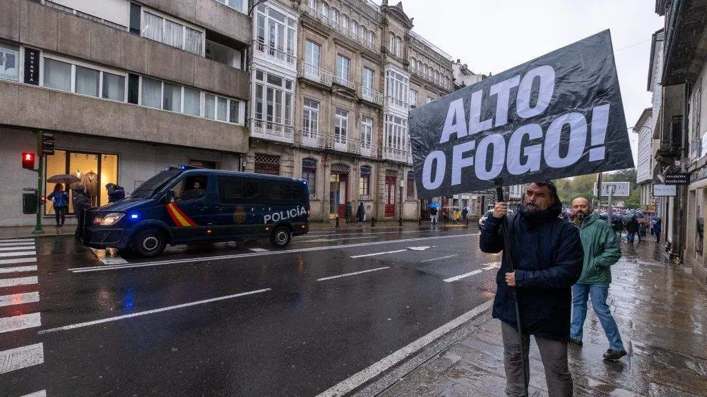 Un home porta un cartel de 'Alto o fogo'. (Foto: C&eacute;sar Arxina / Europa Press)