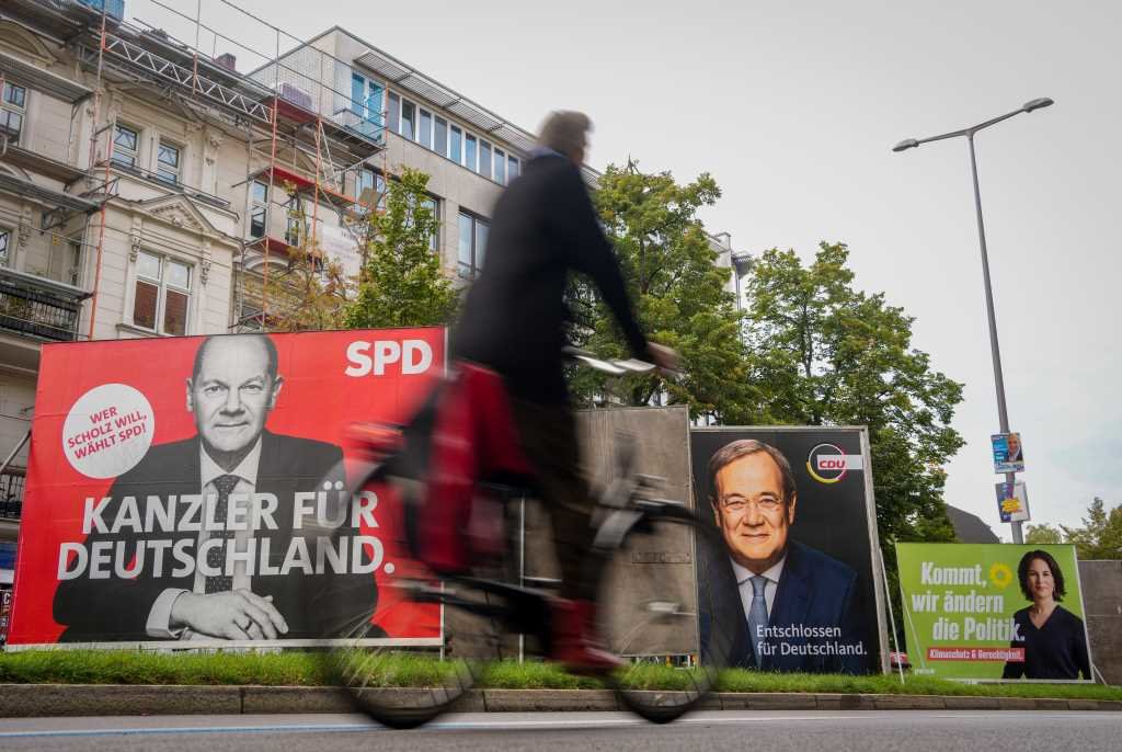 Un ciclista pasa xunto a varios carteis electorais dos comicios en Alemaña (Foto: Kay Nietfeld / Dpa)