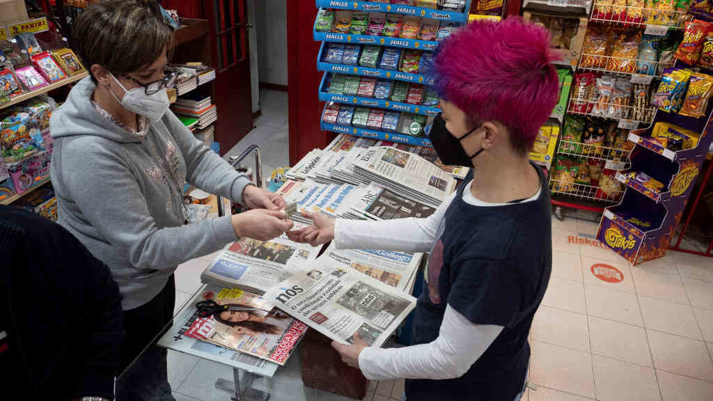 Unha persoa mercando un exemplar do último número do ano de Nós Diario (Arxina)