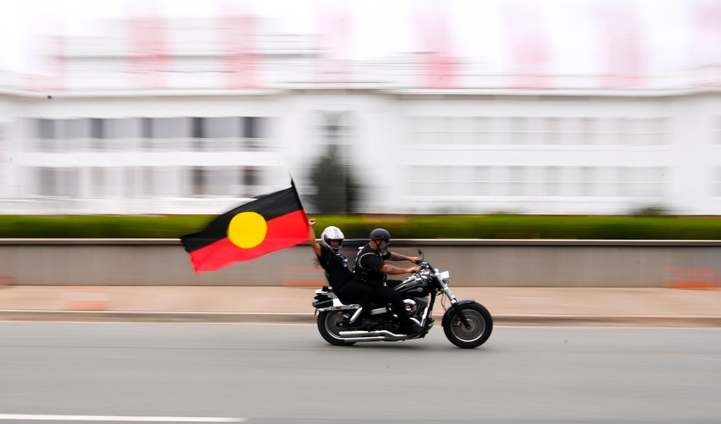 EuropaPress_4217021_bike_rider_holds_an_aboriginal_flag_during_protest_marking_the_50th