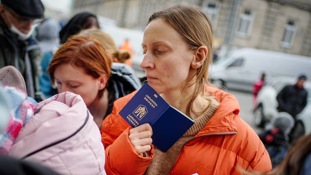 Unha muller mostra o seu pasaporte para entrar en Polonia na cidade fronteiriza de Medyka, esta quinta feira (Foto: Kay Nietfeld / DPA).