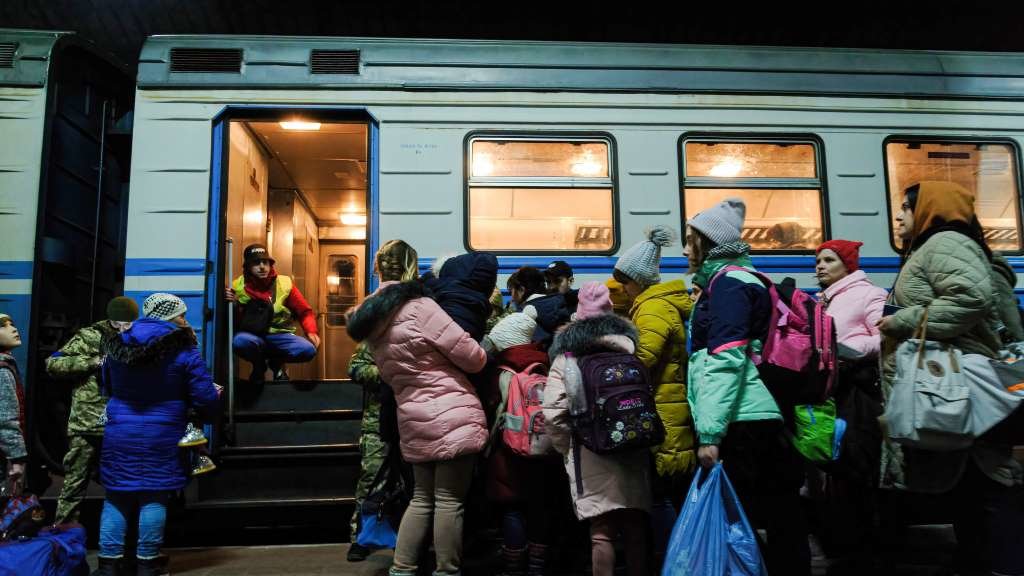 Refuxiadas ucraínas fuxindo do país en tren a través da estación de Lviv (Foto: Mykola Tys / SOPA Images).