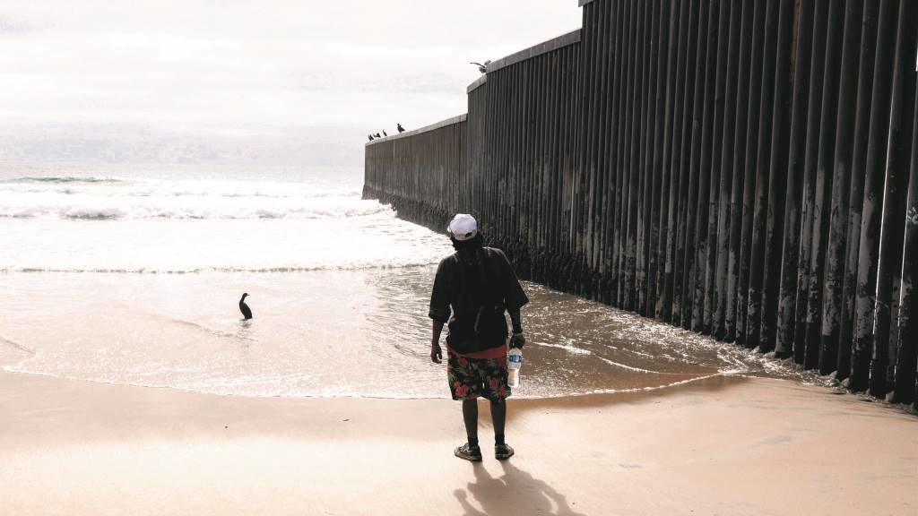 Un migrante observa o muro na fronteira entre Estados Unidos e México, que comezou a construírse no Goberno de Bill Clinton. (Foto: David Peinado / Zuma Press / Contactophoto)