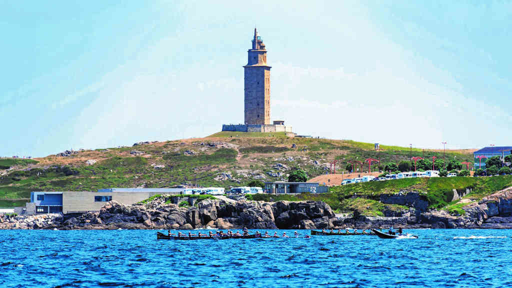 A simbólica Torre de Hércules vixiando a competición das traíñas na enseada do Orzán, na A Coruña. (Foto: Nós Diario)..