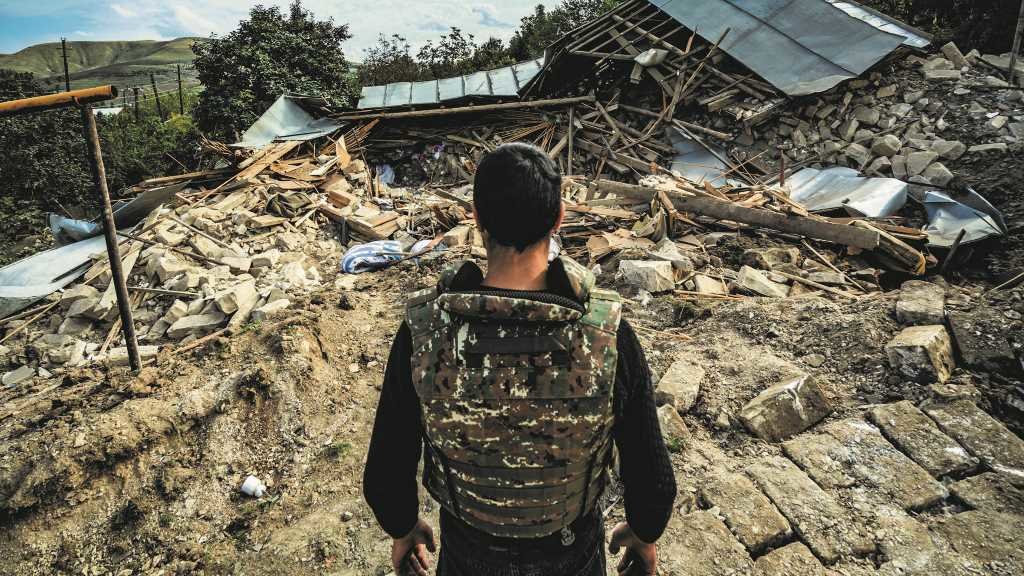 Un miliciano ante as ruínas dunha casa en territorio armenio. (Foto: Celestino Arce Lavin / ZUMA Wire / DPA)