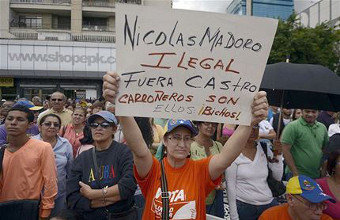 Manifestante portando cartaz contra Nicolás Maduro