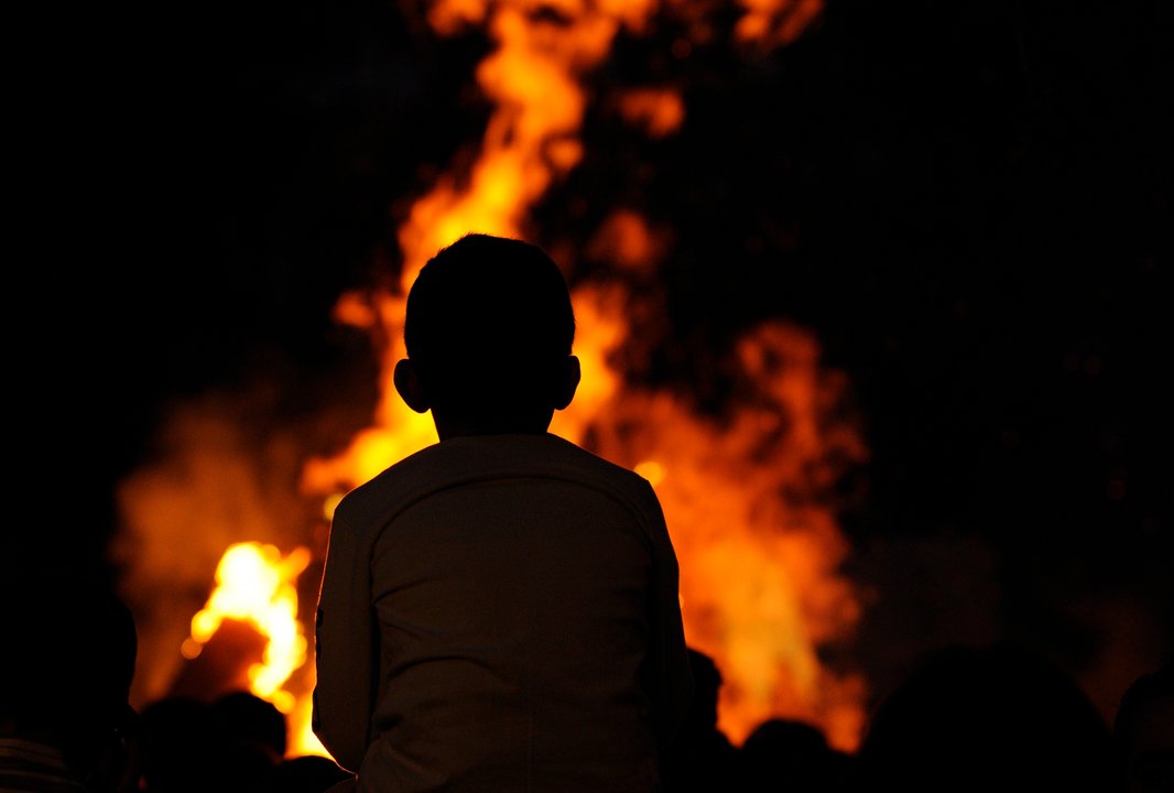 Un neno observa as lapas na noite de San Xoan