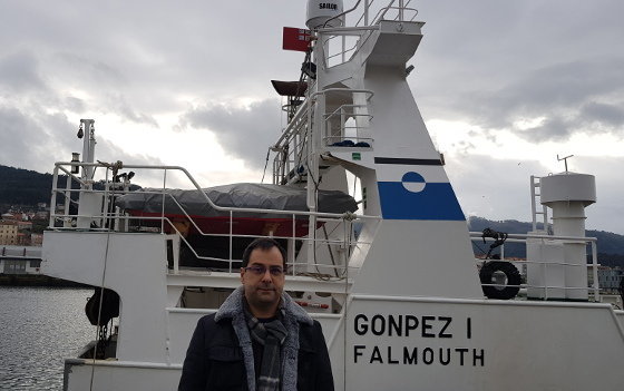 Xosé Rios Cidrás. Detrás, un barco galego abandeirado no Reino Unido para acceder a cupos de pesca sobrantes dese Estado Membro.