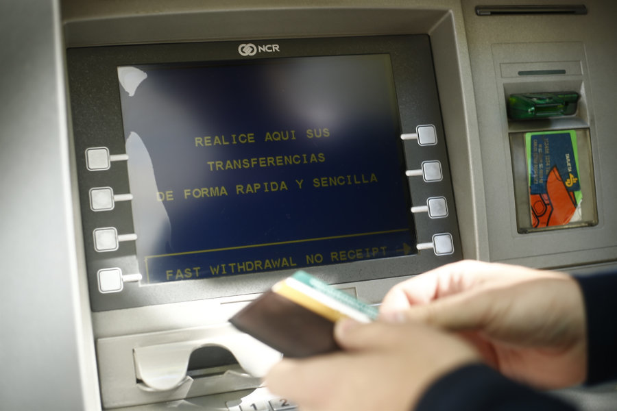 Unha persoa saca cartos dun caixeiro (Europa Press / arquivo)