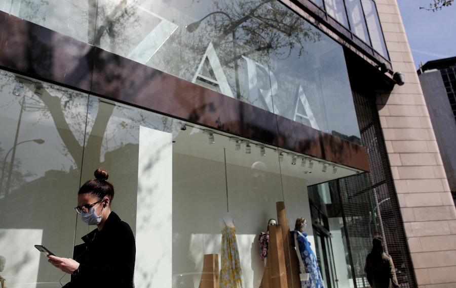 Unha persoa con máscara pasa por diante dunha tenda de Zara (Eduardo Parra / Europa Press)