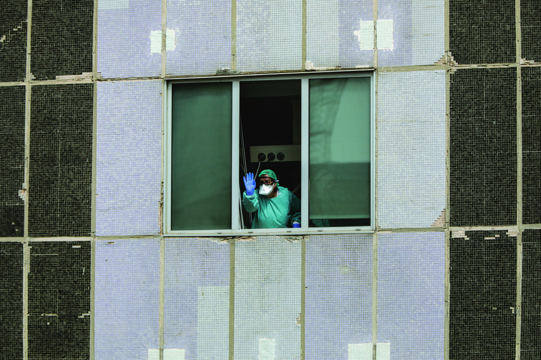 Una sanitaria del Hospital de La Paz totalmente protegida saluda y agradece el apoyo desde una de las ventanas del centro donde se lucha contra el coronavirus, en Madrid (España), a 18 de marzo de 2020.

18 MARZO 2020;CORONAVIRUS;VIRUS;MADRID;LA PAZ

18/3/2020