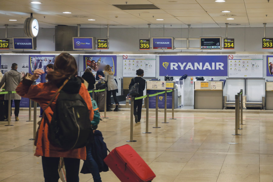 Unha pasaxeira agarda para facturar nun voo de Ryanair (Ricardo Rubio).