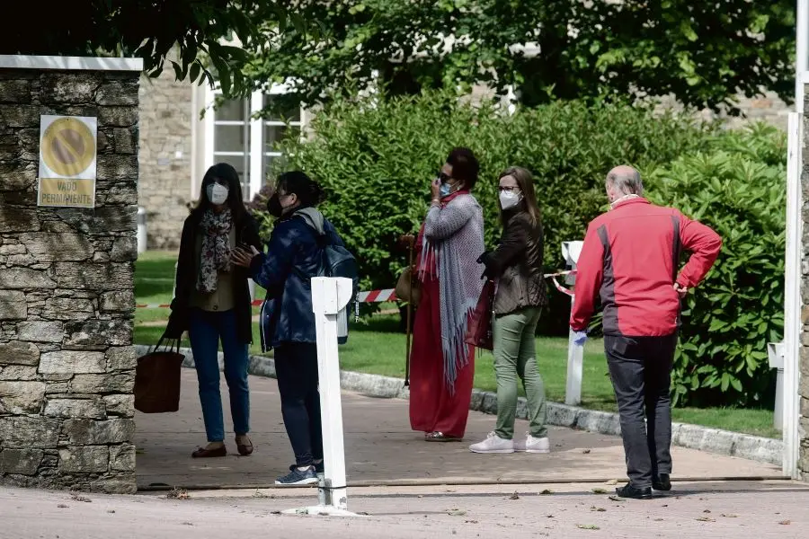 Visitantes agardan a s&uacute;a quenda para entrar na residencia DomusVi San L&aacute;zaro en Compostela (Imaxe: Arxina).