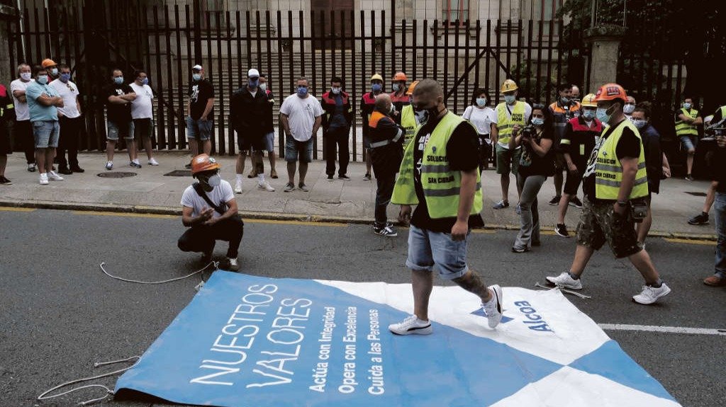 Traballador de Alcoa San Cibrao pisando diante do Parlamento galego un dos carteis corporativos da multinacional norteamericana.(Arxina)