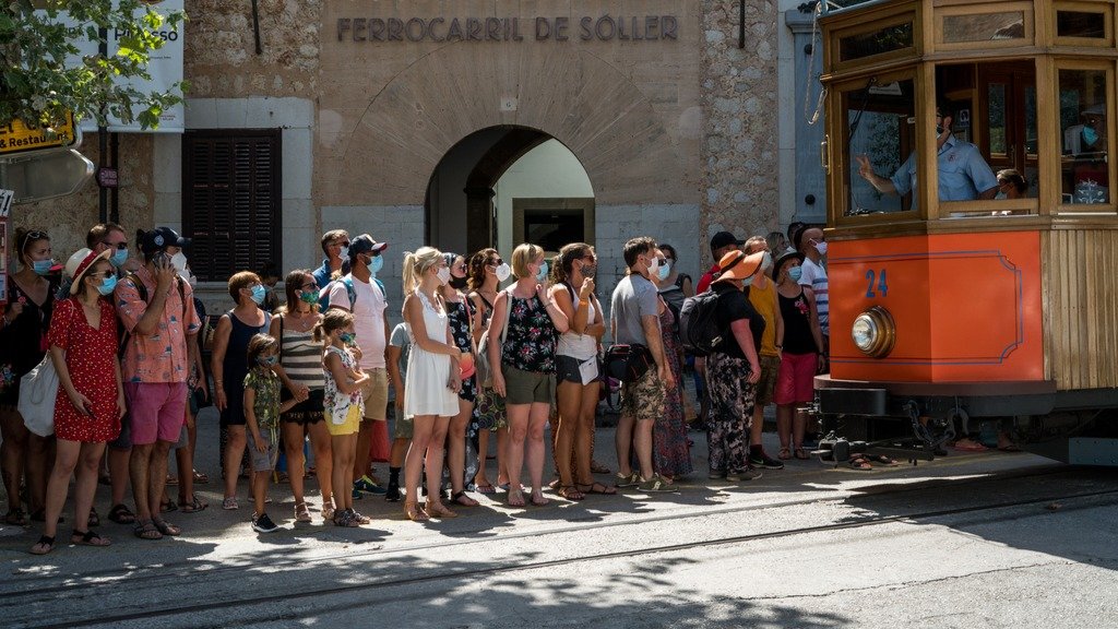 Un grupo de turistas agardan polo tranvía en Soller (Mallorca). (Foto: EP).