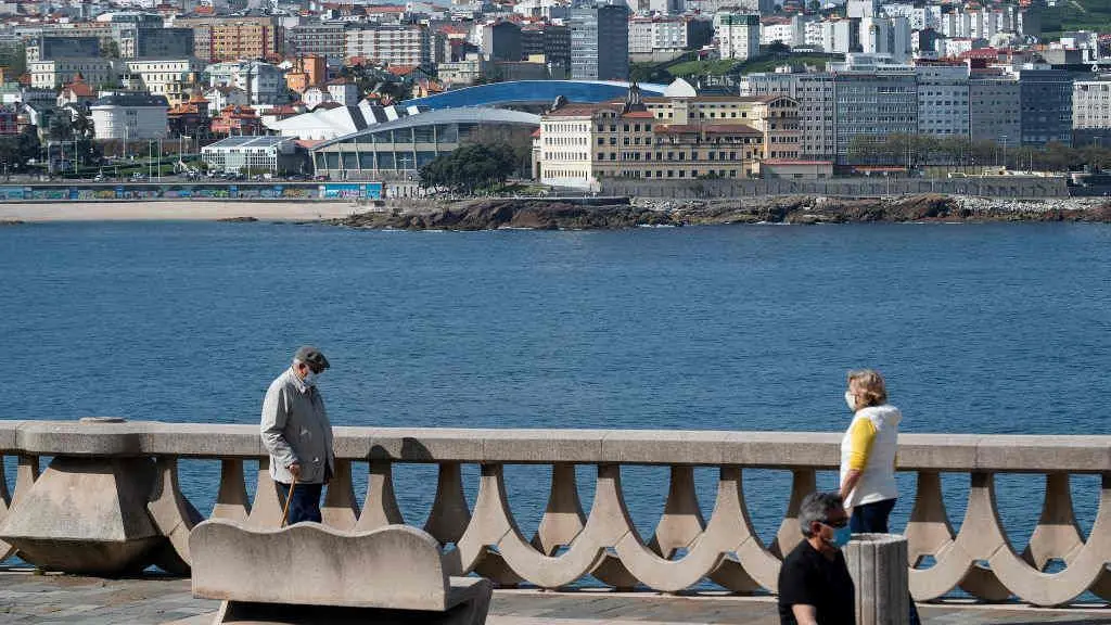 Persoas cami&ntilde;an ao car&oacute;n da praia de Riazor, na Coru&ntilde;a (Foto: Europa Press).