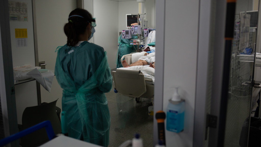 Persoal sanitari cunha persoa ingresada na unidade de cuidados intensivos. (Foto: Europa Press).