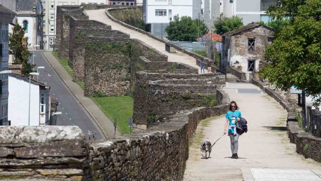 Imaxe de arquivo dunha muller camiñando pola muralla lucense. (Foto: Carlos Castro / Europa Press)
