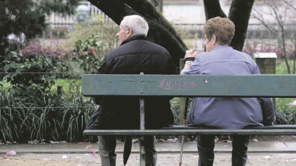 Dúas persoas sentadas nun banco na Alameda  de Compostela. (Foto: Arxina).