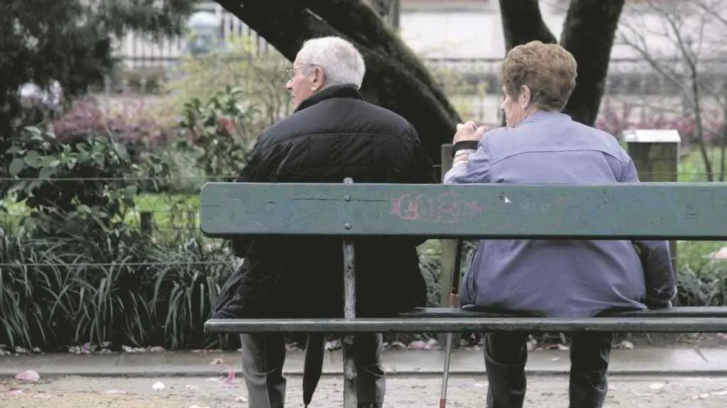 D&uacute;as persoas sentadas nun banco na Alameda  de Compostela. (Foto: Arxina).