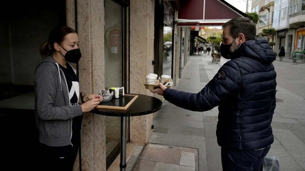 Un home recolle uns caf&eacute;s nun bar de Carballo. (Foto: M. Dylan / Europa Press)