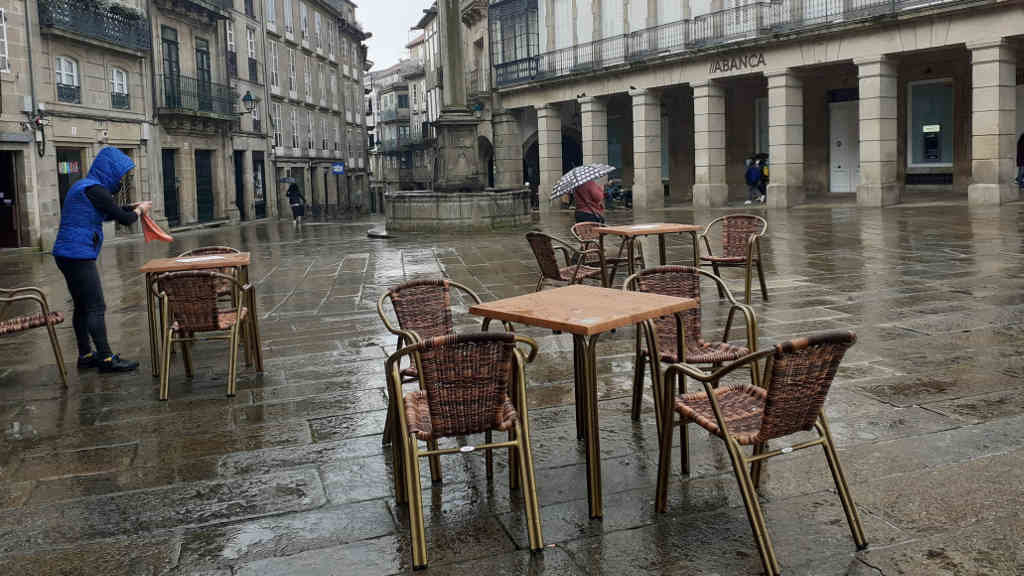 Traballador da hostalaría preparando unha das mesas nunha terraza en Compostela (Foto: Riobó Prada)