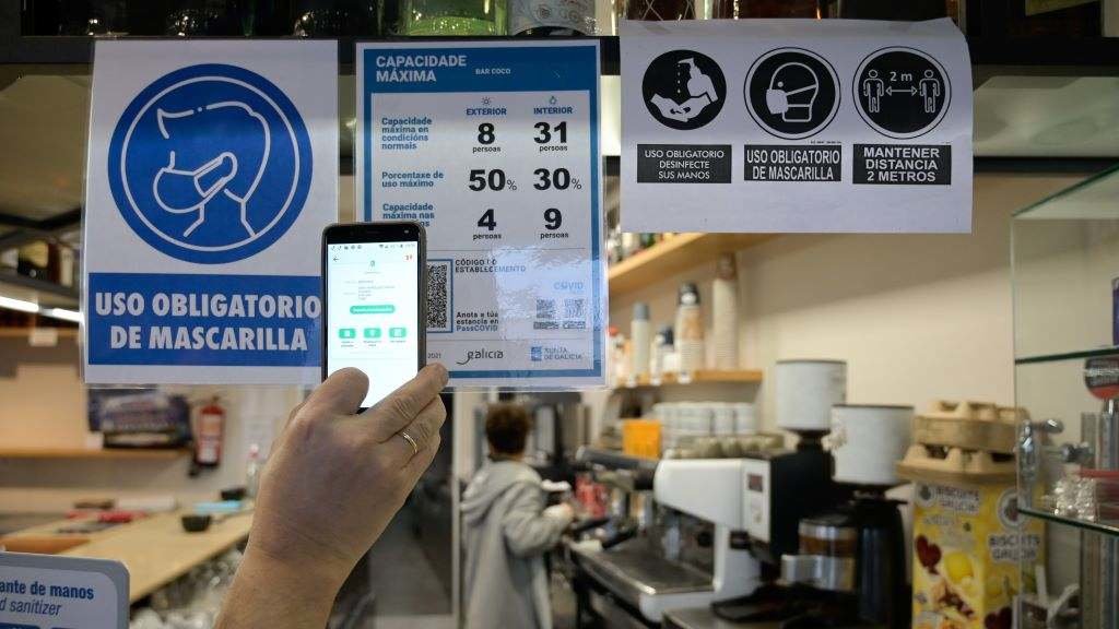 Unha persoa toma una foto para captar o código QR na porta dun restaurante na Coruña. (Foto: M. Dylan / Europa Press)
