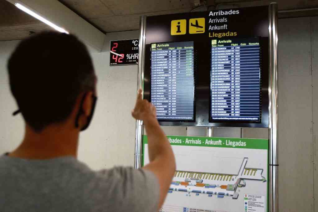 Un mozo contempla as pantallas de información dos voos no aeroporto de Palma, nas Balears.