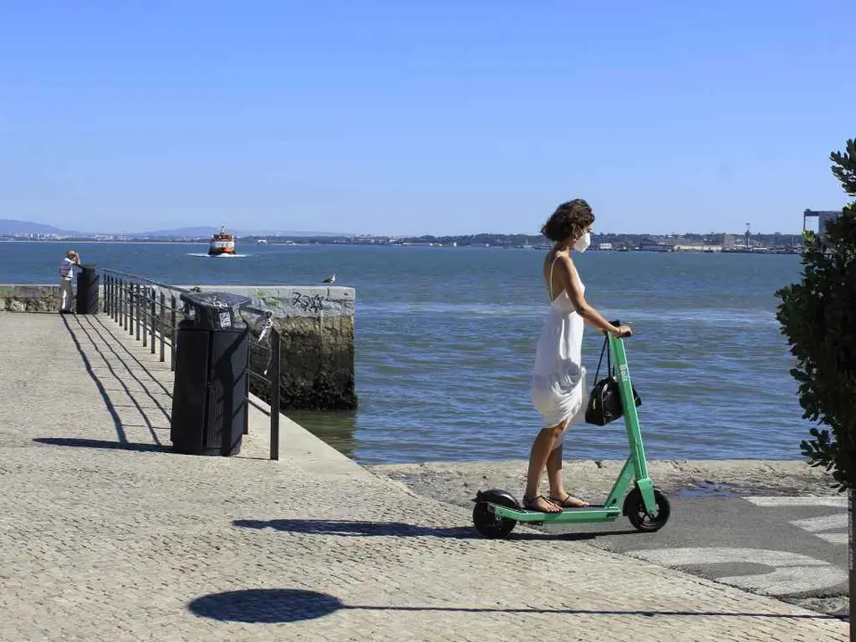 Unha muller, nun patinete, en Lisboa (Imaxe: Edson de Sousa / Europa Press).