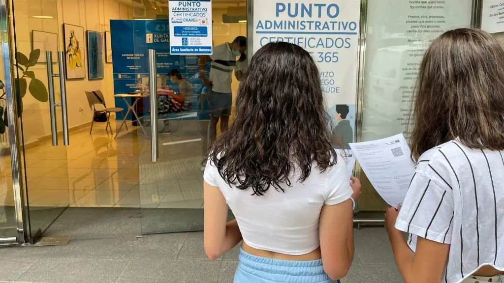D&uacute;as mozas retiran o certificado Covid no punto administrativo de Ourense (Foto: Xunta da Galiza).