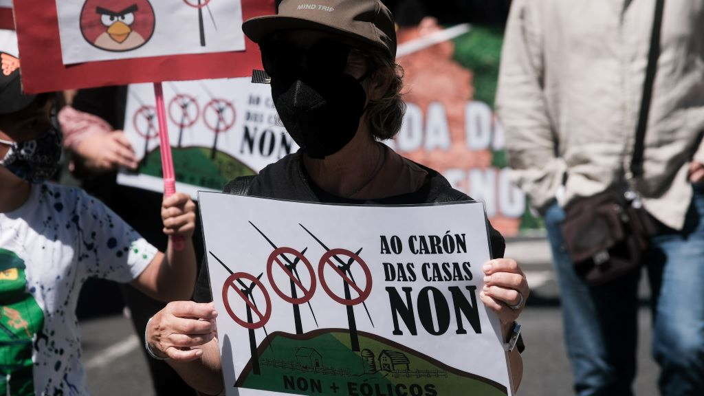 Unha persoa cun cartel en contra dos eólicos na manifestación decorrida en xuño en Compostela. (Foto: César Arxina / Europa Press) #eólicos #manifestación #enerxía