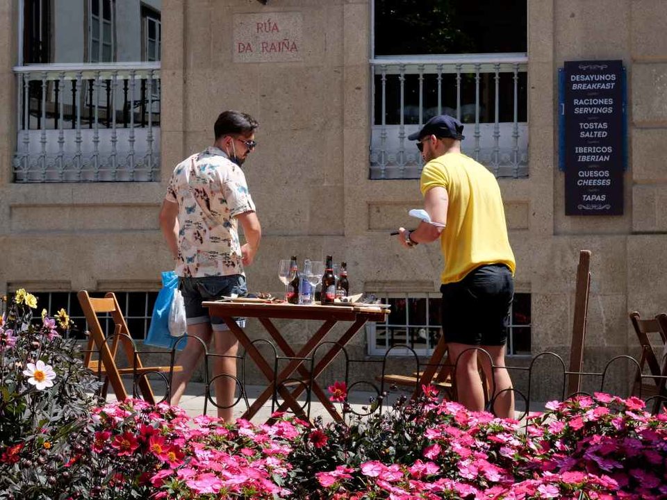 Dous homes abandonan unha terraza da Rua da Raiña de Santiago, o día en que o TSXG declara nula a petición de certificado Covid para entrar en hostelería.