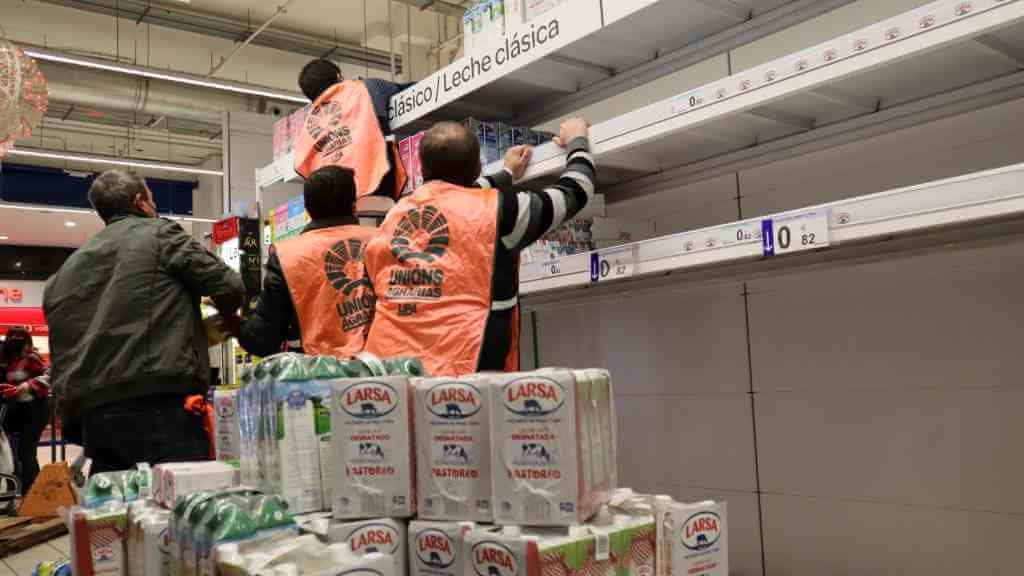 Varias persoas axudan a retirar dos andeis do Carrefour das Cancelas, en Compostela, os produtos de Lactalis e Capsa (Foto: Nós Diario).