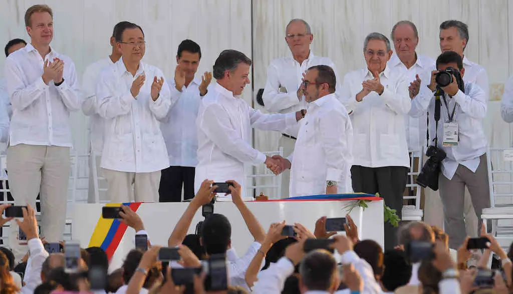 Juan Manuel Santos, presidente naquela altura de Colombia, e Rodrigo Londo&ntilde;o, l&iacute;der das FARC, ap&oacute;s asinar os acordos de paz. (Foto: Presidencia do Salvador)