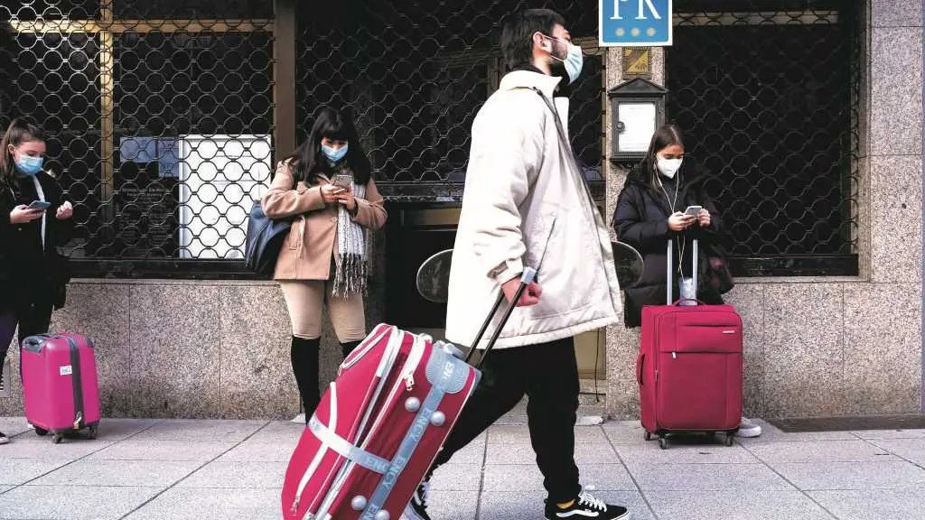 A metade das mozas e mozos con contrato laboral ocupan un posto que require dunha cualificaci&oacute;n acad&eacute;mica inferior &aacute; que pos&uacute;en. Na imaxe, xente nova agardando polo autob&uacute;s en Compostela (Foto: Arxina).