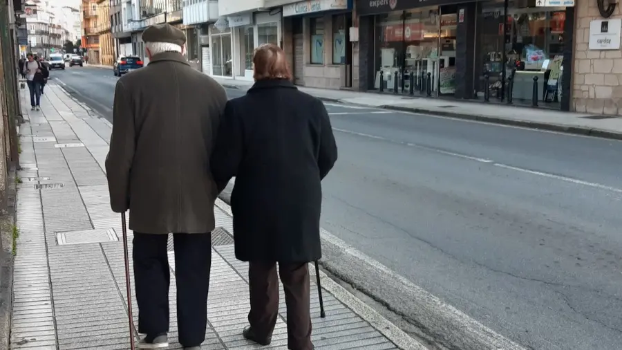Duas personas maiores cami&ntilde;an polas r&uacute;as de Vilagarc&iacute;a. (Foto: Xo&aacute;n Roberes)