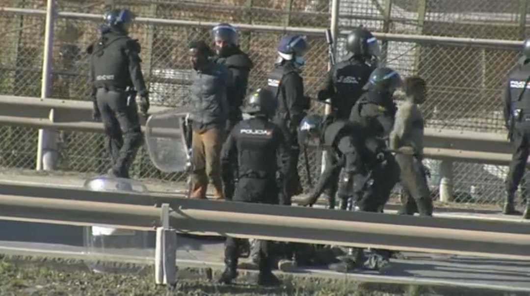 Axentes policiais trasladando varios migrantes que acaban de cruzar a verxa de Melilla. (Foto: RTVE)