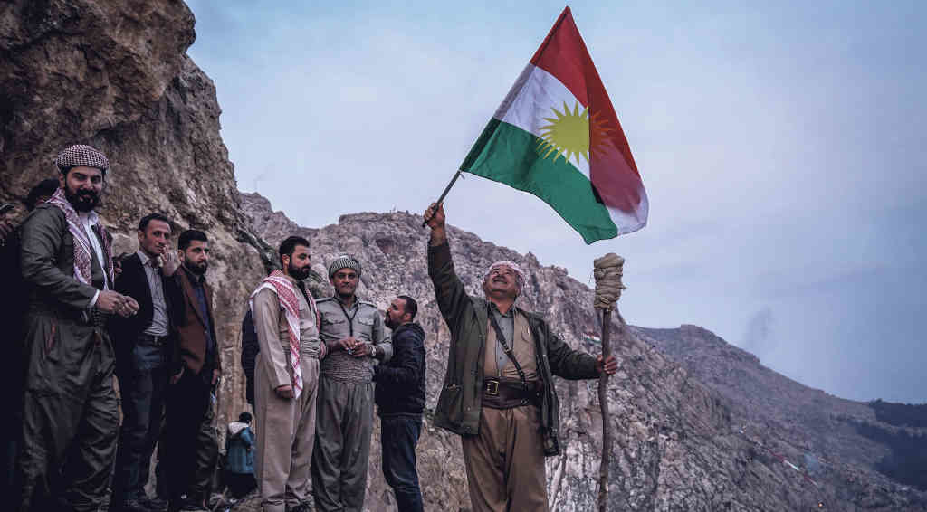 Home sostén bandeira kurda. (Foto: Ismael Adnan)