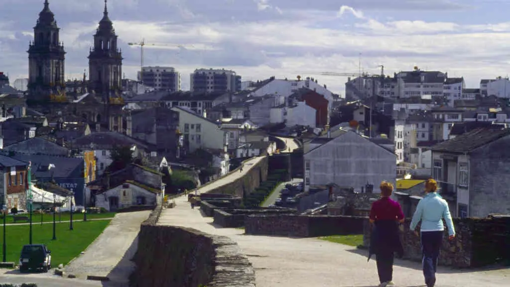 Persoas cami&ntilde;an pola muralla de Lugo (Foto: Europa Press).