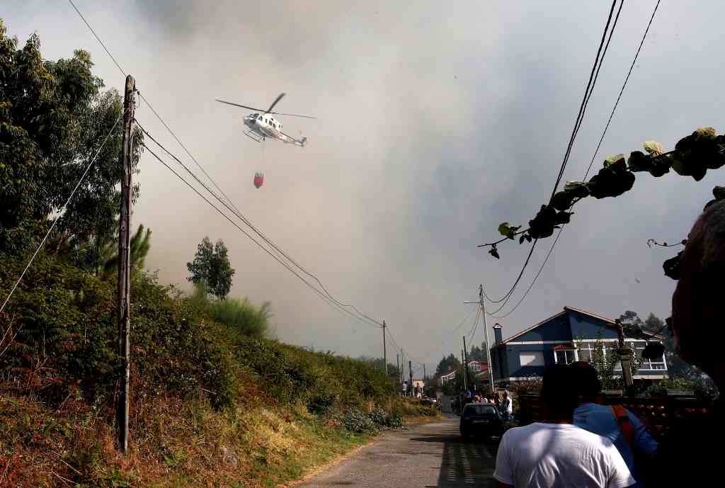 Un helicóptero traballa nos labores de extinción do incendio de Moaña. (Foto: Europa Press)