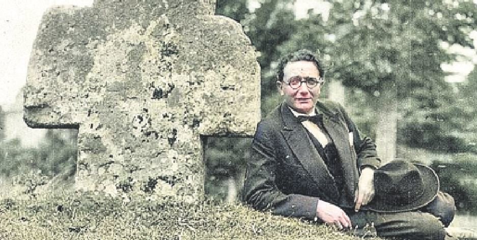 Alfonso Daniel Rodríguez Castelao diante dunha das cruces de pedra na Bretaña, nunha imaxe coloreada. (Foto: Nós Diario)