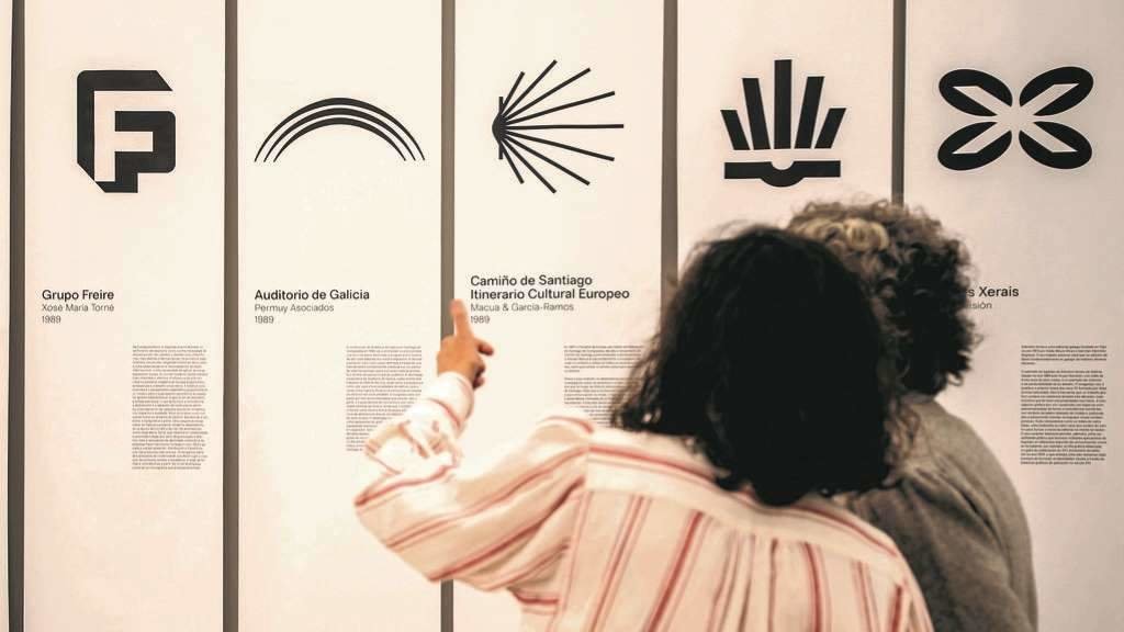 Dúas persoas observan a exposición 'A Galiza deseñada', inaugurada esta sexta feira na Coruña. (Foto: Casteleiro)