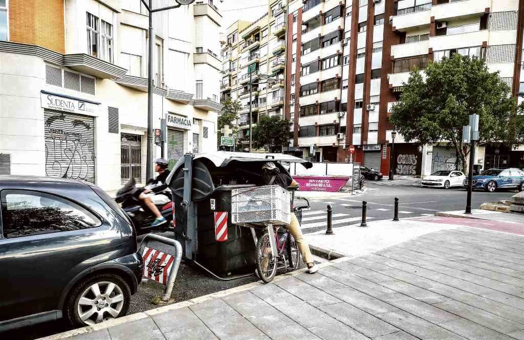 Un cidadán buscando alimentos nun contedor de lixo en Santiago de Compostela. (Foto: Nós Diario)