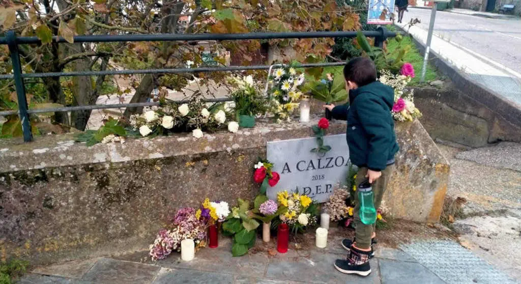 Unha crianza deposita flores na l&aacute;pida que apareceu na praia da Calzoa, en Vigo. (Foto: Ana Prado Comesa&ntilde;a).