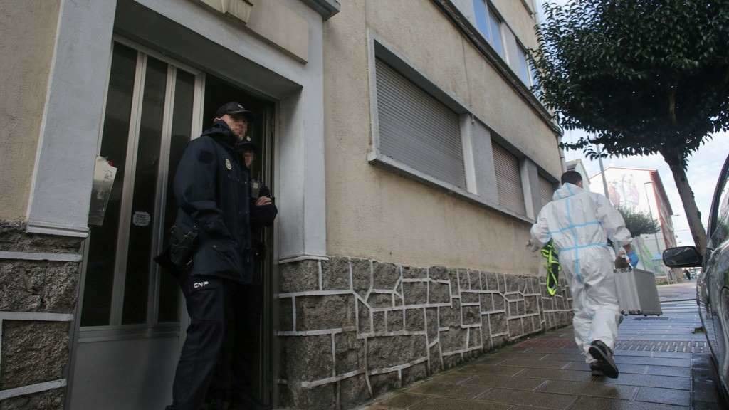 Un axente da Policía Nacional, na mañá desta terza feira, diante da porta do edificio onde foi asasinada Cristina Cabo. (Foto: Carlos Castro / Europa Press)