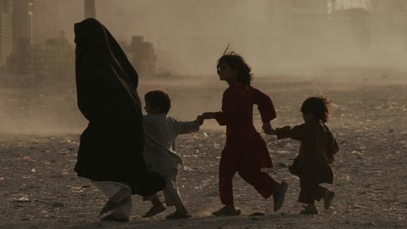 Unha muller fuxindo de Kabul (Afganistán) coas súas crianzas o pasado ano. (Foto: Europa Press)