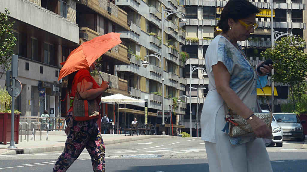 Dúas persoas camiñan por una vía en plena onda de calor, a 12 de xullo de 2022, en Ourense (Foto: Rosa Veiga / Europa Press).