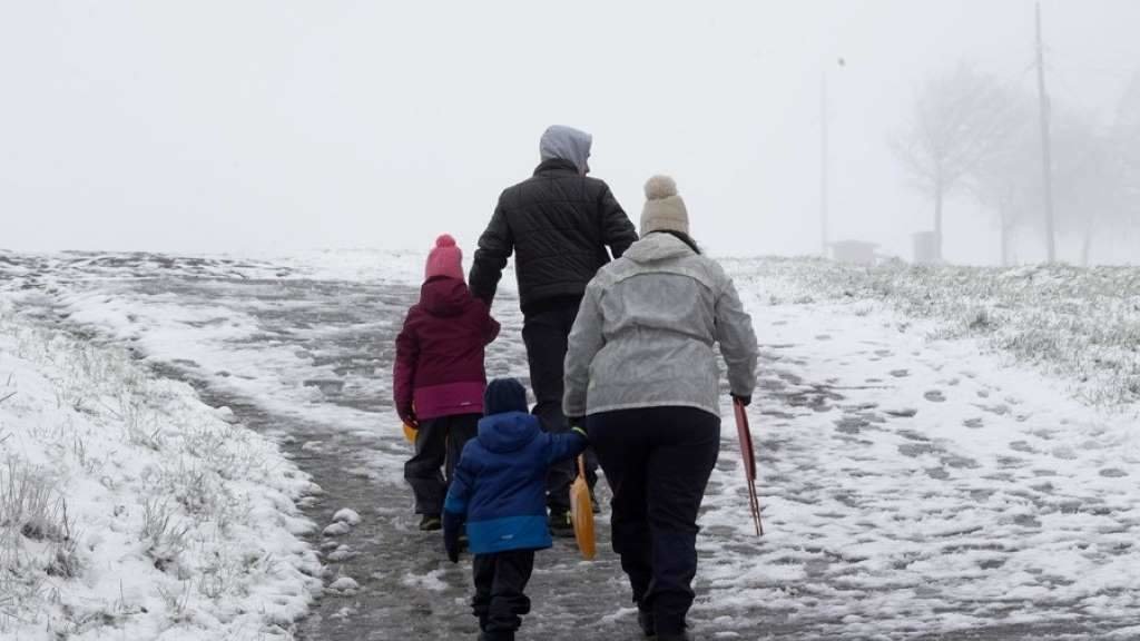 Na imaxe, unha familia tenta avanzar nun camiño tomado pola neve en Pedrafita do Cebreiro, que marcou outro dos mínimos desta noite, con -4,4 graos. (Foto: Carlos Castro / Europa Press)