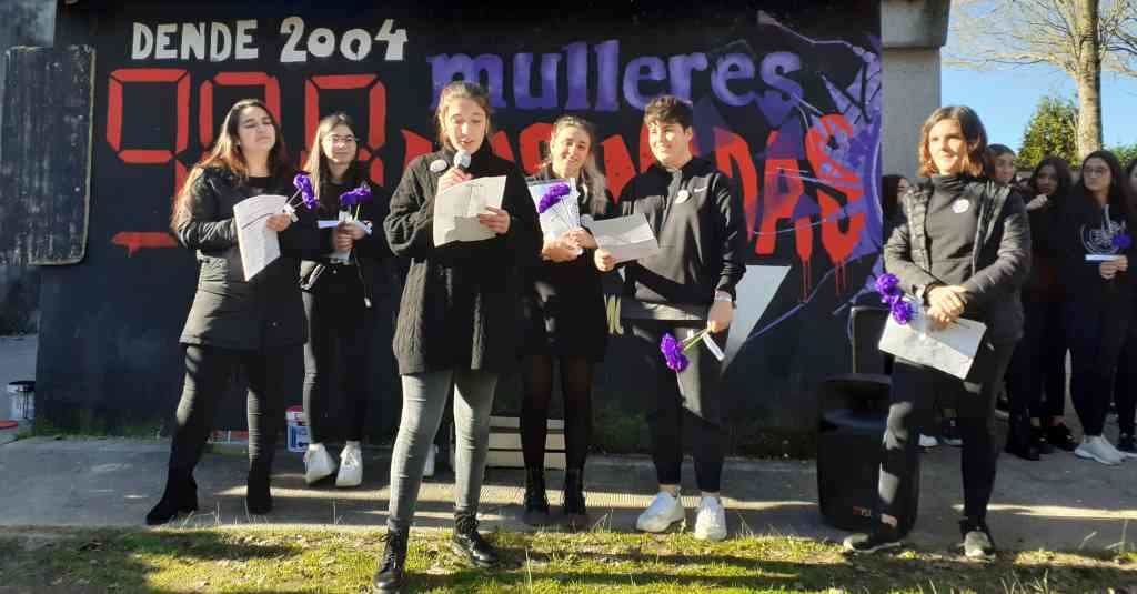 O alumnado de Rianxo lendo 
un manifesto polo 25-N diante dun mural co número 
de mulleres asasinadas nas 
últimas décadas. (Foto: Nós Diario)