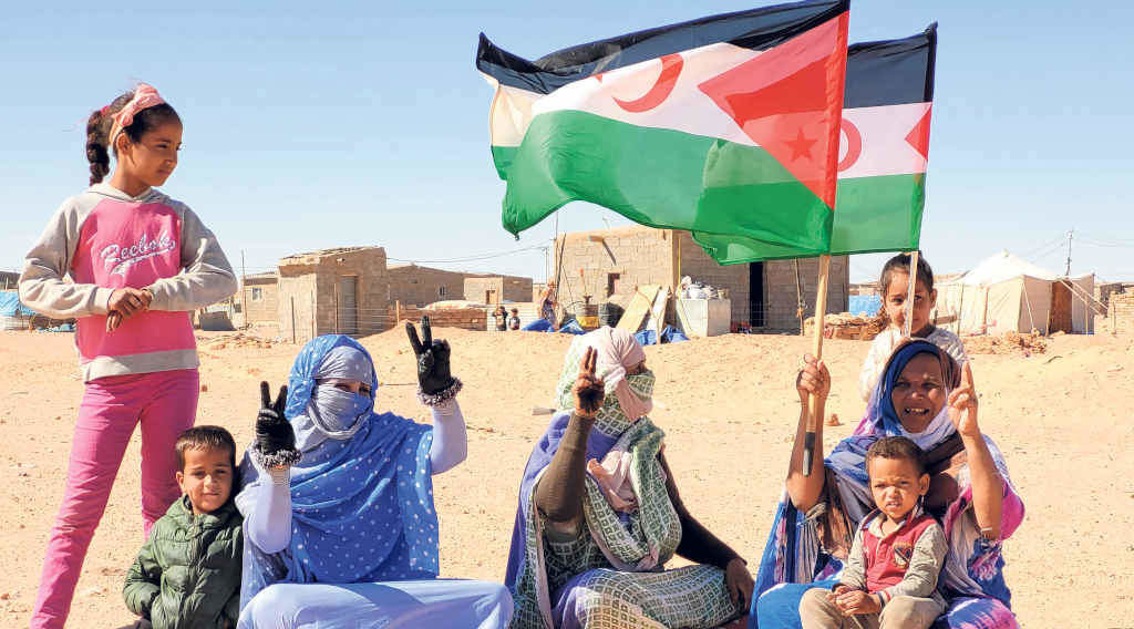 Tres saharauís fan o símbolo da vitoria no campo de refuxiadas e refuxiados (Foto: cedida)